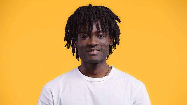 happy happy african american man with dreadlocks isolated on yellow - 写真・画像