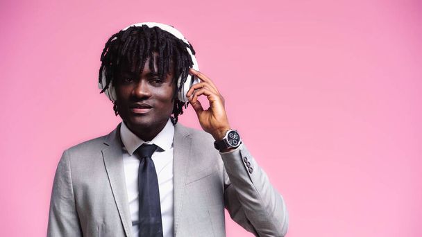 cheerful african american businessman with wireless headphones isolated on pink - Fotoğraf, Görsel