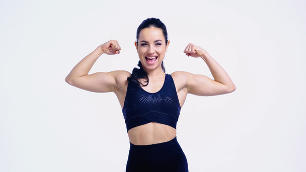 fröhliche Sportlerin zeigt Muskeln isoliert auf weißem Grund - Foto, Bild