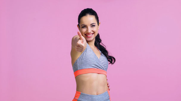 pleased sportswoman showing thumb up isolated on pink - Photo, Image