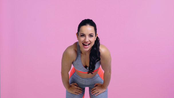 excited sportswoman encouraging while bending isolated on pink  - Photo, Image