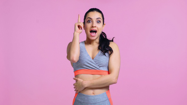 збуджена молода жінка в спортивному одязі, вказуючи пальцем ізольовано на рожевому
 - Фото, зображення