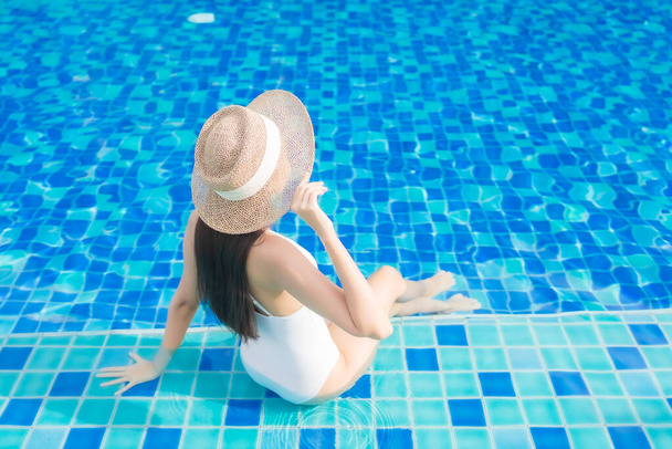 Retrato hermosa joven mujer asiática relajarse sonrisa alrededor de la piscina al aire libre en el complejo hotelero - Foto, imagen