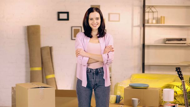 cheerful woman standing with crossed arms in new home - Photo, Image