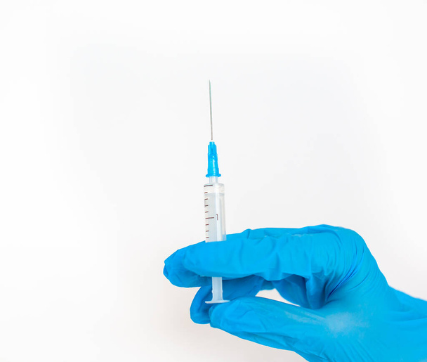O médico segura uma seringa de vacinação num fundo branco. Um tiro do coronovírus. Vacinação contra infecções perigosas ou tratamento de doenças - Foto, Imagem
