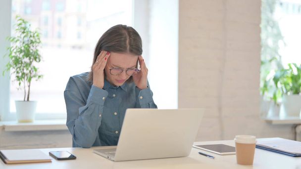 Frau mit Laptop hat Kopfschmerzen  - Foto, Bild