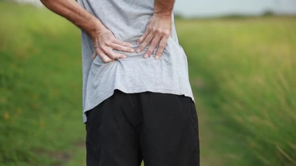 Спортсмен з Азії після вправ має біль у спині, травму від тренування. - Кадри, відео