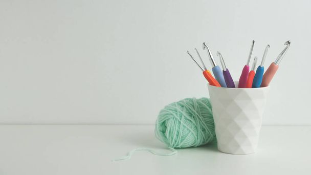 crochets multicolores en tasse blanche. Fond blanc. Espace de copie - Photo, image