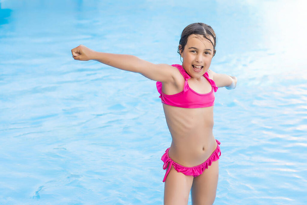 Pretty little girl swimming in outdoor pool and have a fun - Foto, Imagem