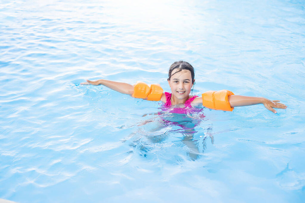 Bella bambina nuotare in piscina all'aperto e divertirsi - Foto, immagini
