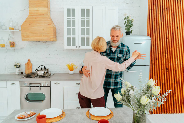 husband and wife dance at home during breakfast - Foto, Imagen