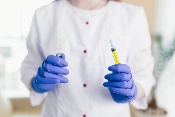woman's hands dial the vaccine into a syringe, close-up photo - 写真・画像