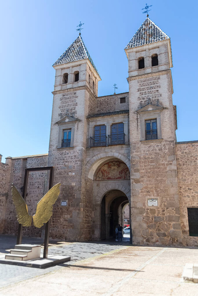 トレドスペイン- 05 12 2021年:旧ビサグラ門(プエルタ・デル・アルフォンソ6世)での内部ビュートレド要塞の記念碑的なムーア人の主要都市の門の入り口、黄金の天使の翼の彫刻と屋内展示 - 写真・画像