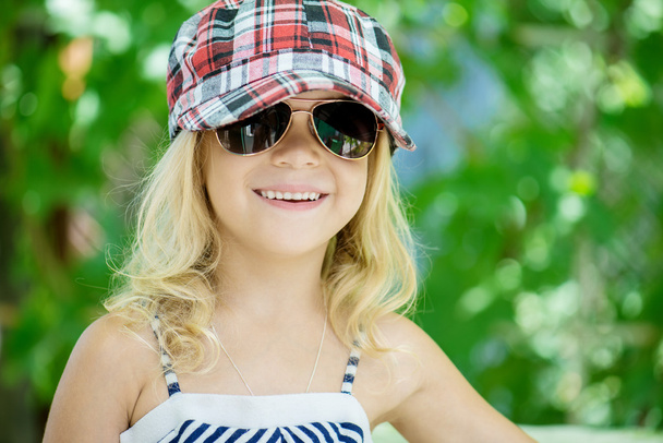 klein meisje in groene zomer stadspark - Foto, afbeelding