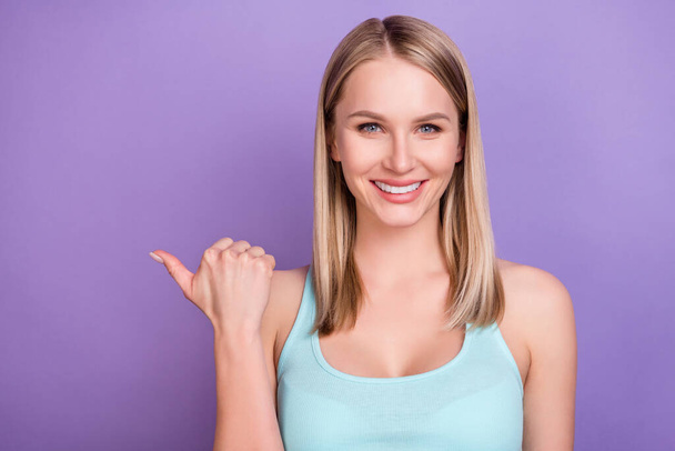 Photo of sweet blond young lady point empty space wear blue top isolated on violet color background - Фото, зображення