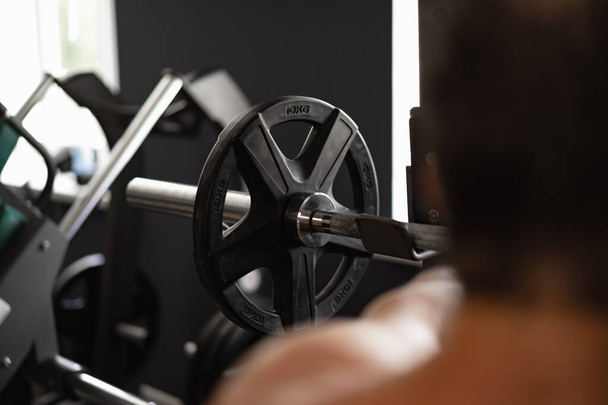 Back view of a man bodybuilder exercising in a gym - Φωτογραφία, εικόνα