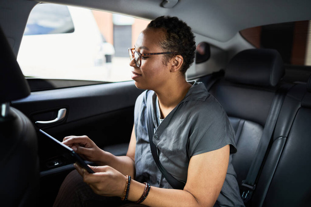 Kobieta korzystająca z tabletu w samochodzie - Zdjęcie, obraz