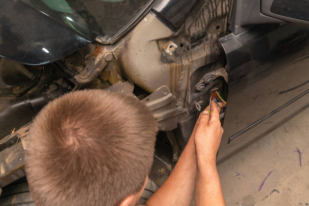 Специалист по ремонту электропроводки автомобиля решает проблему с чипами, проводами - Фото, изображение