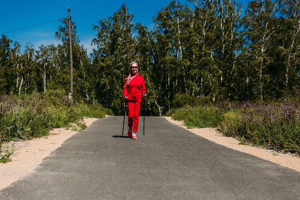 sixty-year-old Scandinavian athlete with sticks outdoors - Valokuva, kuva
