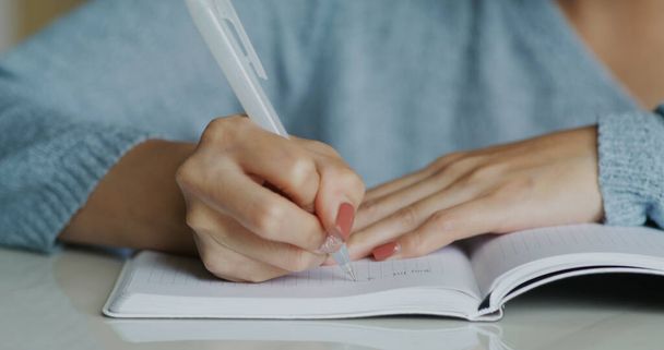 Vrouw schrijft op notitieboek - Foto, afbeelding
