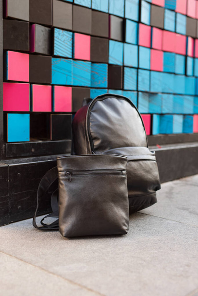 Set of backpack and messenger near colourful wall - Foto, imagen