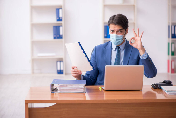 Young businessman employee working in the office during pandemic - 写真・画像