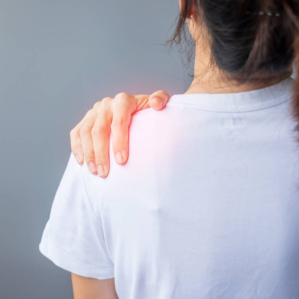 woman with her shoulder sprain, muscle painful during overwork. Girl having body problem after wake up. Shoulder ache, Scapular pain, office syndrome and ergonomic concept - Photo, Image