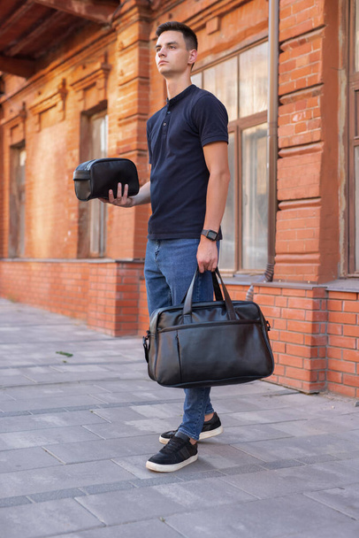 Man walking in city with black leather bag - Фото, изображение