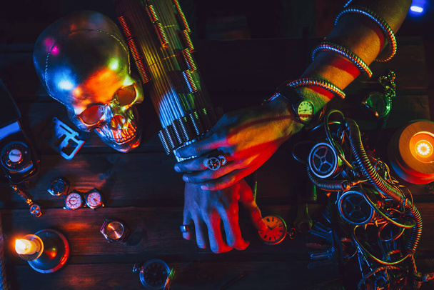 Cyberpunk sfeer. Handen van een mannelijke uitvinder ingenieur op een tafel met verschillende steampunk mechanismen - Foto, afbeelding