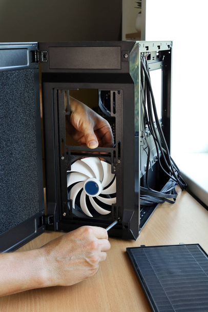 Manos tornillo ventilador de refrigeración de la caja de la computadora al montar un nuevo PC - Foto, imagen