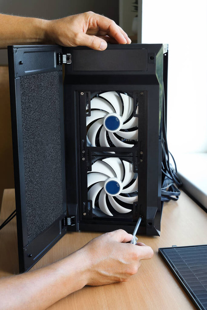 Manos fijadas con tornillos ventilador de refrigeración unidad de marco de la computadora al montar un nuevo PC - Foto, imagen