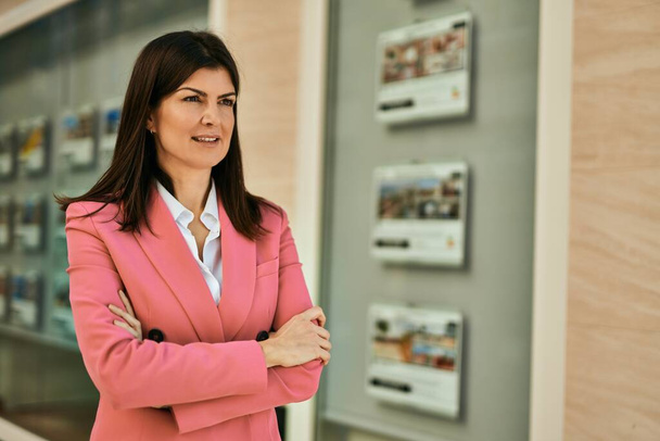 Middle age business woman working as real estate agent. Sales woman smiling happy at the office - 写真・画像