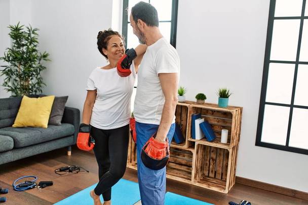 Middle age hispanic couple smiling happy training boxing at home. - Fotoğraf, Görsel