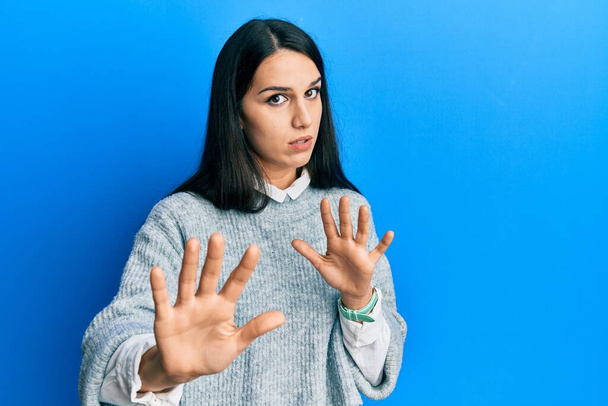 Young hispanic woman wearing casual clothes moving away hands palms showing refusal and denial with afraid and disgusting expression. stop and forbidden.  - Photo, Image