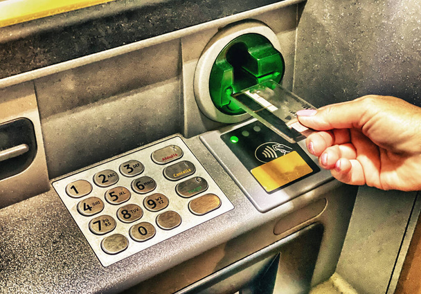 Женщина снимает деньги в банкомате. - Фото, изображение