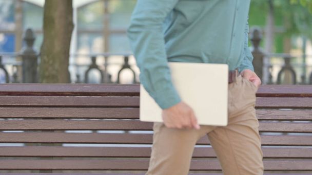 Man with Laptop Going Away from Bench - Photo, Image