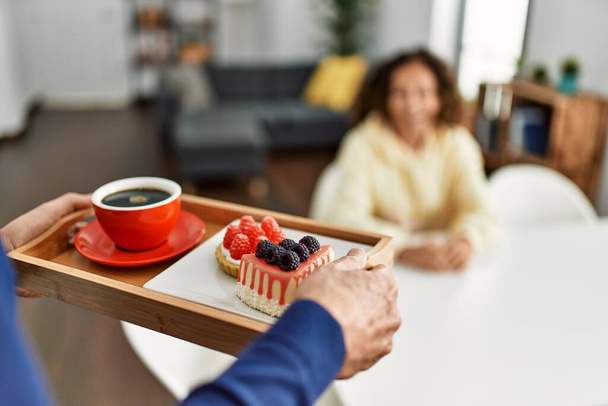 Homem segurando bandeja com café da manhã surpreendendo sua esposa em casa. - Foto, Imagem