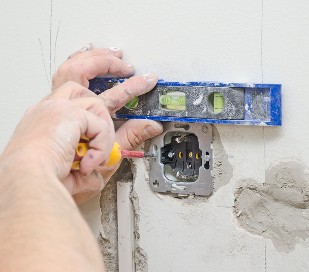 Certified electrician installing socket for light switch. - Photo, Image