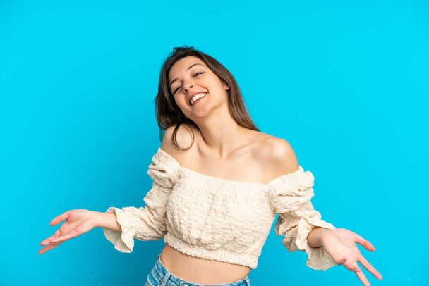 Young caucasian woman isolated on blue background happy and smiling - Photo, Image