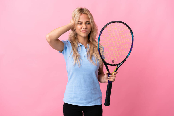 Молода російська жінка грає в теніс ізольованою на пурпуровому фоні розчарованою і покриваючою вухами. - Фото, зображення