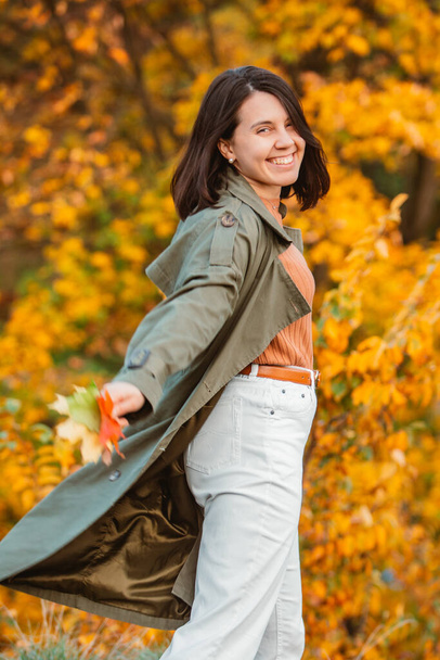 hermosa mujer sonriente delante de las hojas doradas de otoño - Foto, imagen
