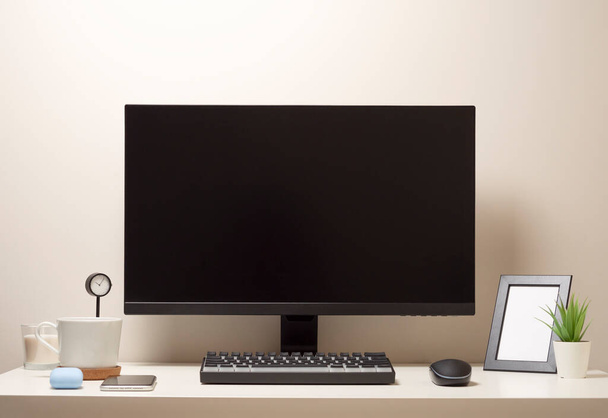 Компьютер с беспроводной клавиатурой и беспроводной мышью на белом столе с черными часами фото рамка мобильного телефона белая чашка кофе - Фото, изображение