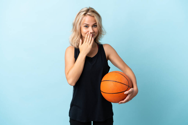 若いですロシア人女性プレイバスケットボール隔離上の青背景幸せと笑顔カバー口とともに手 - 写真・画像