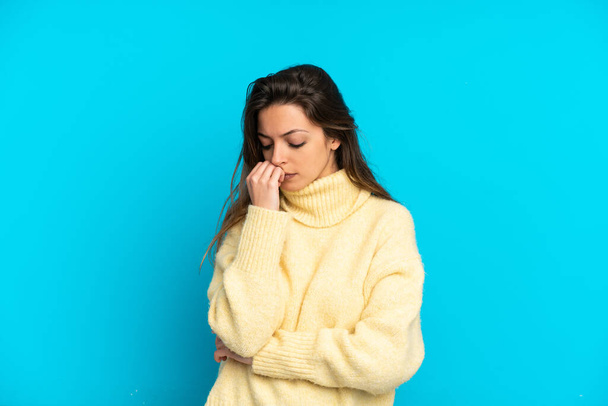 Young caucasian woman isolated on blue background having doubts - Photo, Image