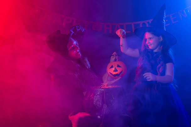 Menina engraçada e mulher em trajes de bruxas para o Halloween com Jack de abóbora - Foto, Imagem