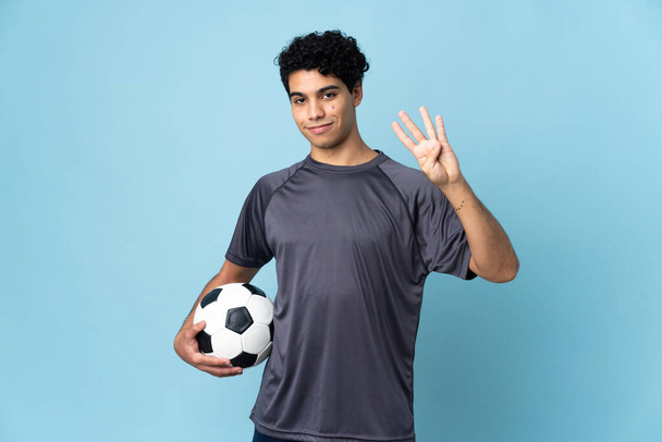 Venezuelan football player man over isolated background happy and counting four with fingers - Photo, Image