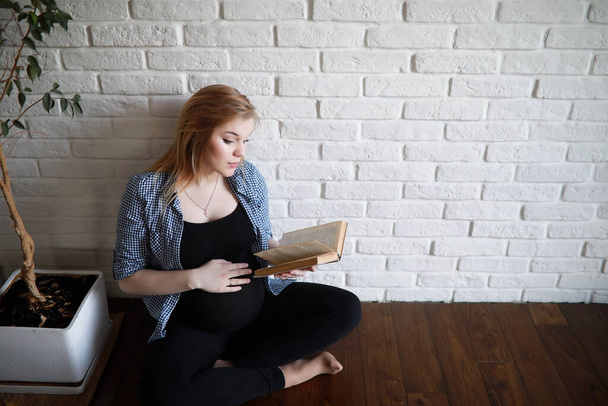 Беременная молодая красивая девушка на девятом месяце в помещении - Фото, изображение