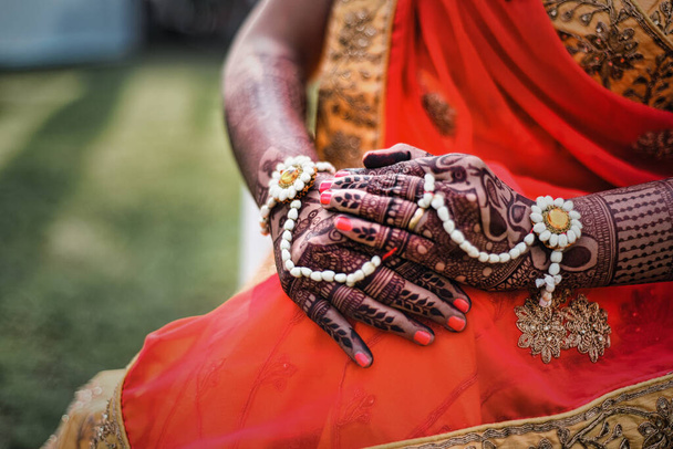 A closeup of hands of an Indian female covered with tattoos and bracelets - Valokuva, kuva