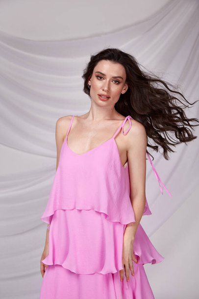Beautiful sexy woman wear light long pink color dress summer collection cotton casual style tanned body brunette hair beautiful face makeup white background studio. - Fotografie, Obrázek