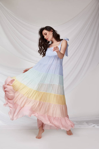 Beautiful sexy woman wear light multicolor silk dress summer collection party casual style tanned body brunette hair beautiful face makeup white background studio. - 写真・画像